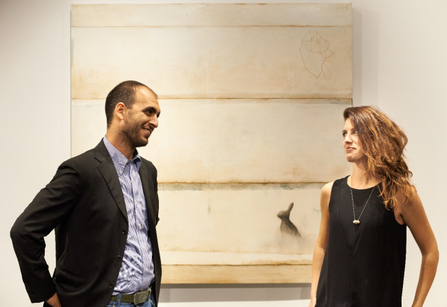 Martina e Stefano Gagliardi nella nuova sede de Il Vicolo a Milano, alle loro spalle un'opera di Mirko Baricchi
